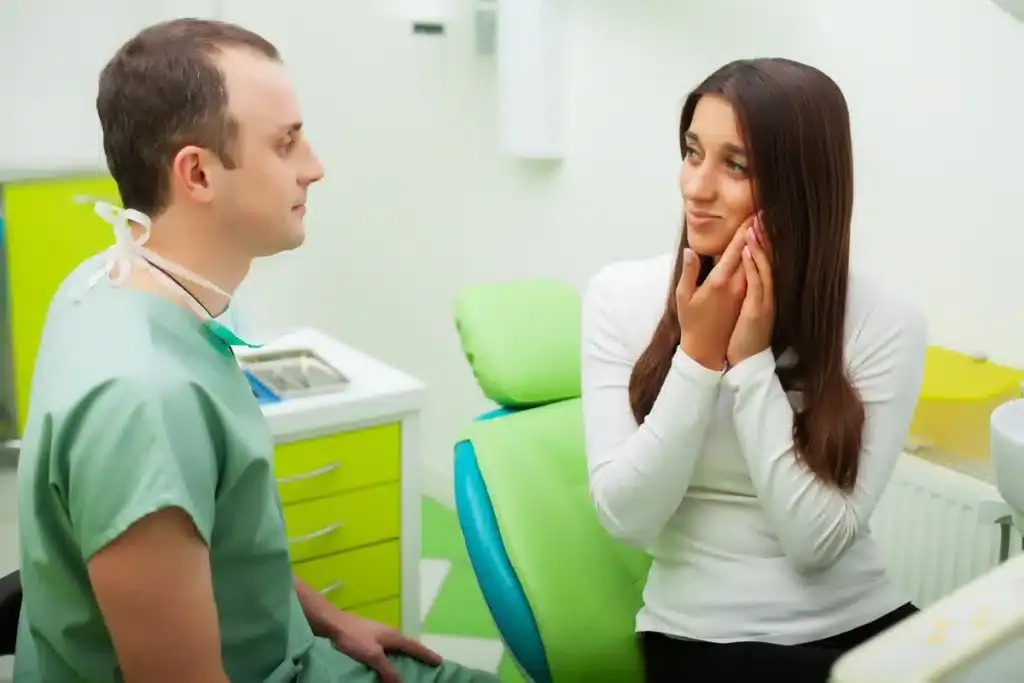 Woman with TMJ going to the doctor to treat TMJ and relieve pain.