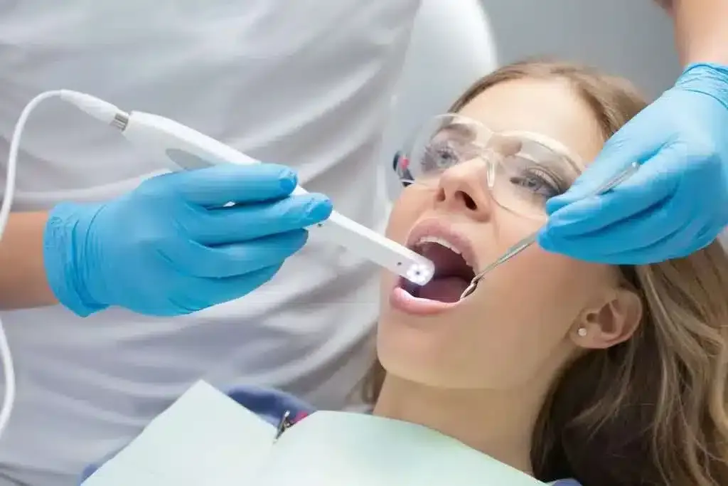 Patient receiving treatment with an intraoral camera