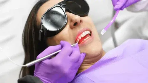Advantages Of Low Light Laser Therapy In Dentistry image of a woman receiving treatment of Low Light Laser Therapy In Dentistry at a dentist’s hospital.