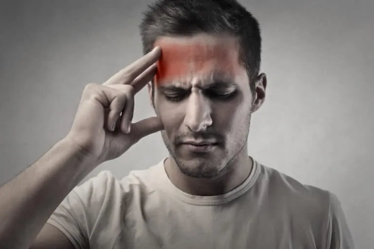 A man holding his forehead.