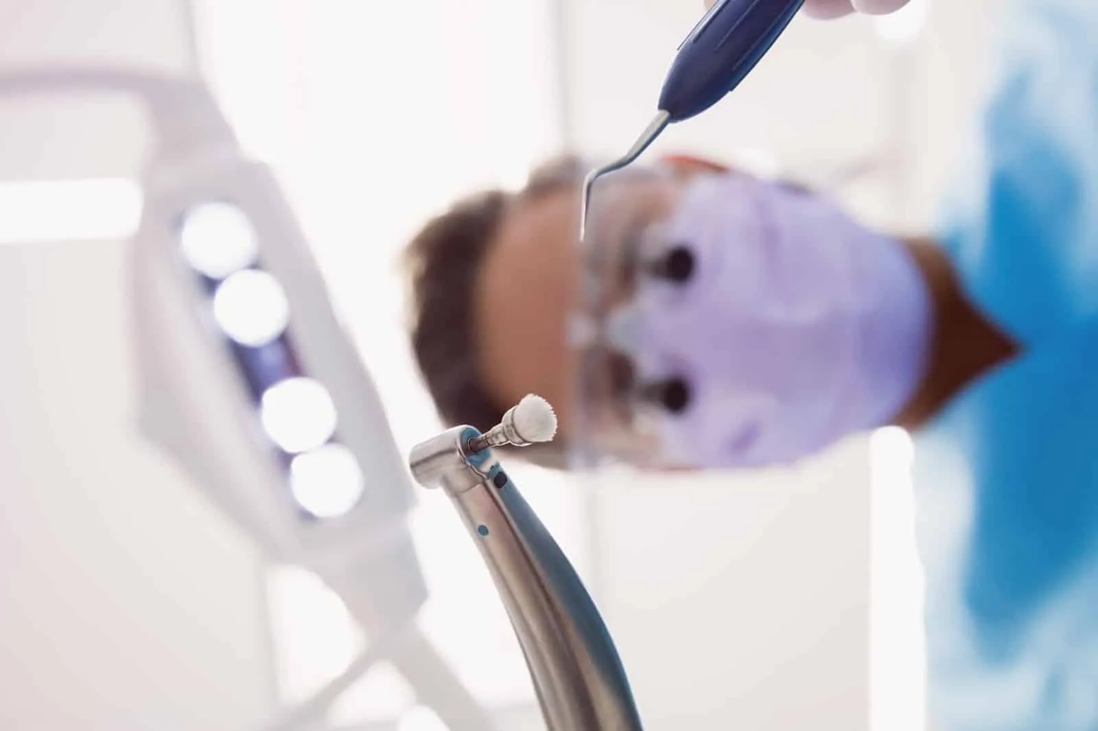 A close up shot of a dentist holding his dental tools.