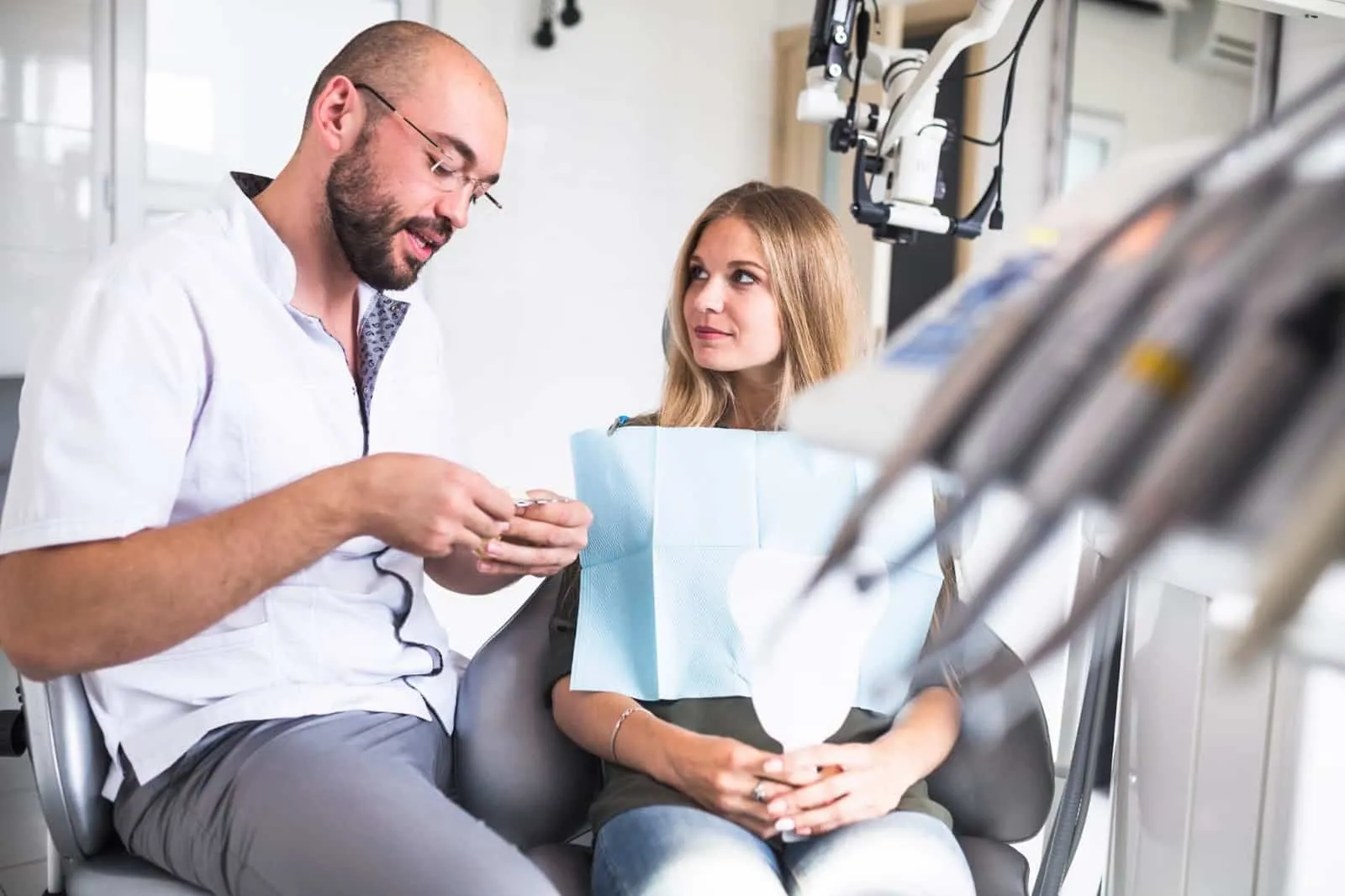A dentist explains a procedure to his patient.