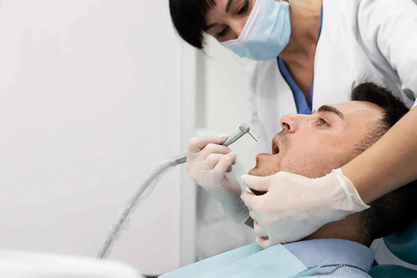 A dentist works on her patient’s teeth.